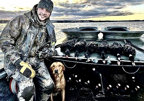  Man and dog pose with ducks caught