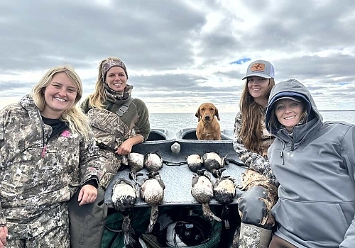  Group aboard boat poses with ducks hunted