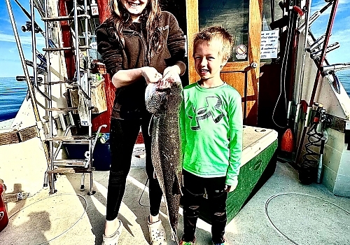 Family poses with fish caught on fishing trip