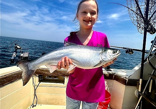 Young girl poses with fish caught on family trip