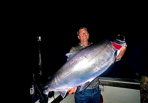 Holding up huge fish caught at night