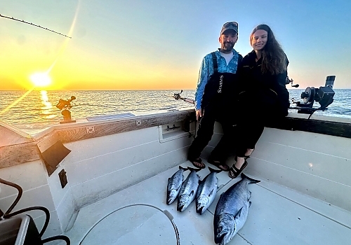Young couple poses with catch on dock
