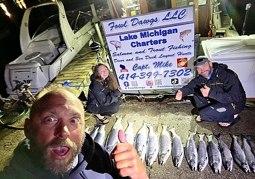 Group holding up fish caught at night