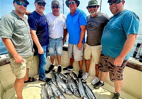 Group holding up fish caught on dock