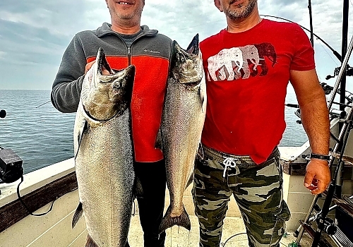 Two fishermen hold up their catch
