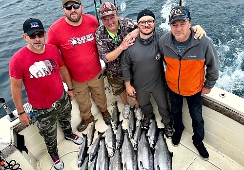 Group holding up fish caught on trip