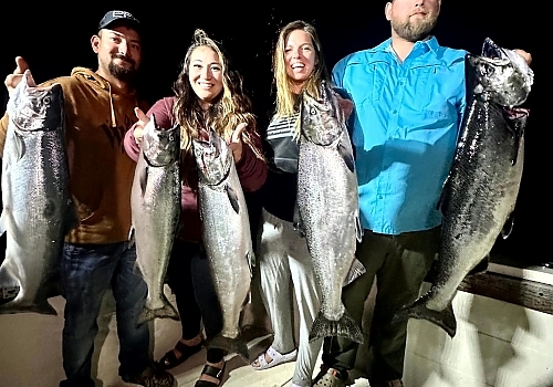 Group holding up fish caught at night