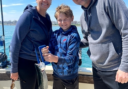 Family poses with fish caught on fishing trip